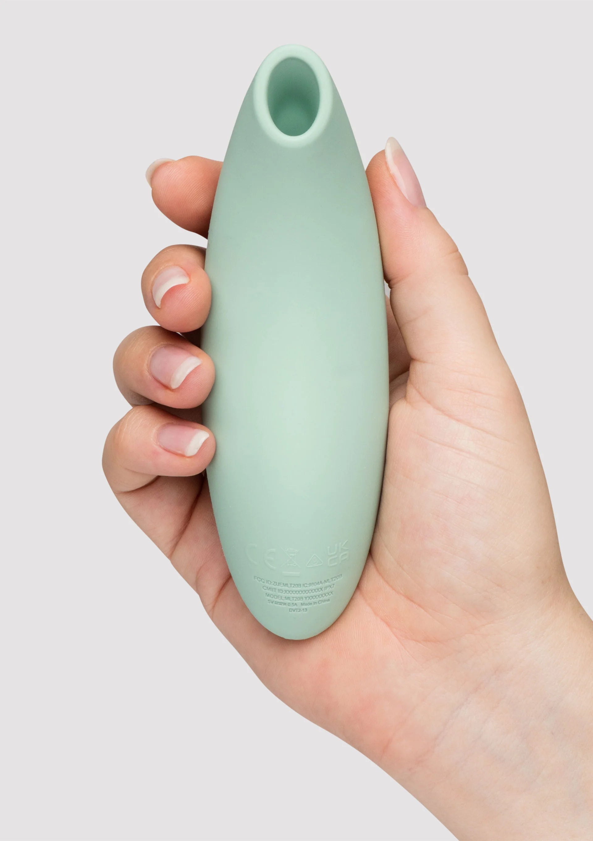 Mintgroene vibrator vastgehouden in hand, met open ronde opening