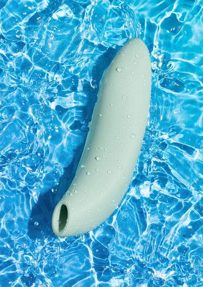 Lichtgroene vibrator in blauw water, met druppels op het oppervlak