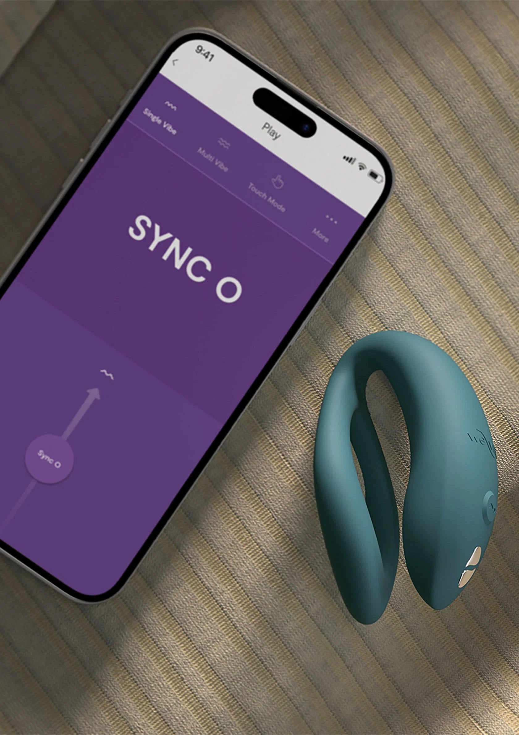 Blauwe O-vormige vibrator naast smartphone met app-interface