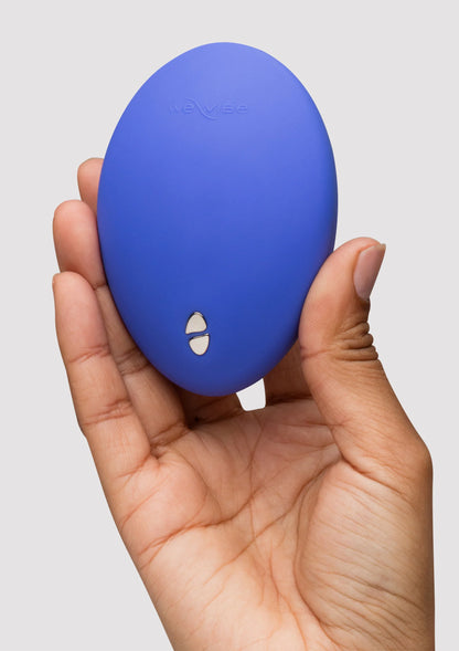 blauwe ovale vibrator met weVibe-opdruk op achterzijde, in hand