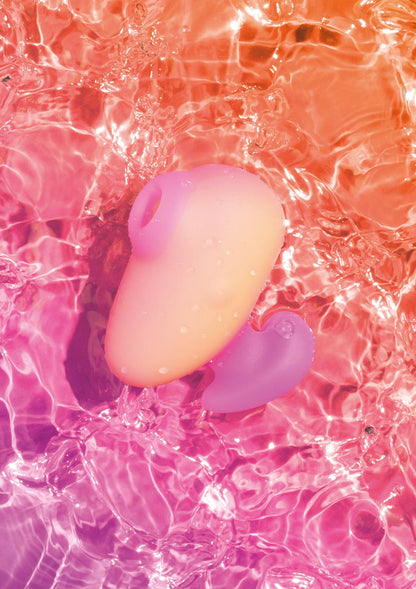 Roze vibrator in water met paars hulpstuk, onder schuimende belletjes