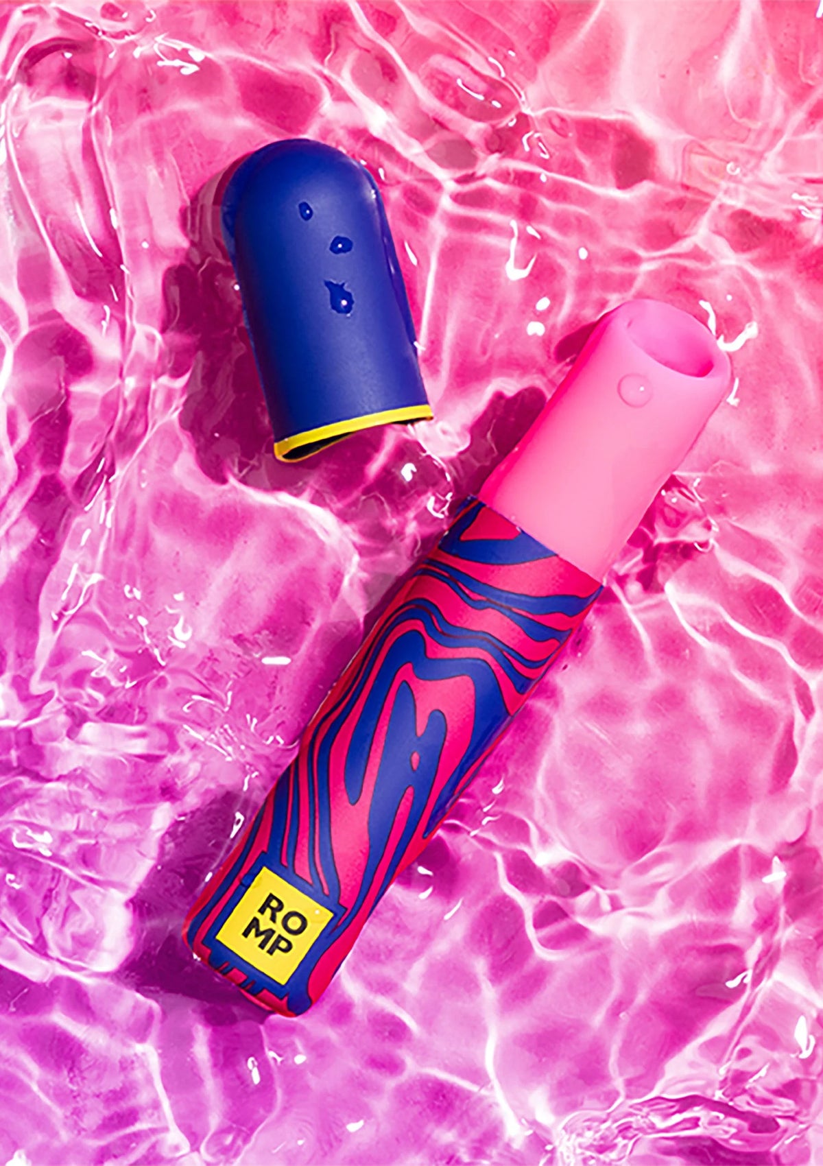 Airpressure-lipstick van Romp op roze/glanzend oppervlak, felroze en donkerblauwe huls