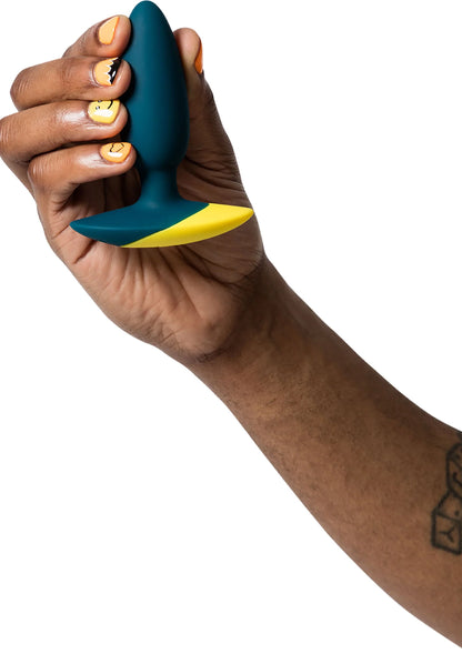 Vibrerende anale plug donkerblauw met gele punt, vastgehouden in de hand