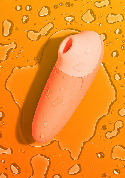 Oranje stimulatieapparaat met waterdruppels op het oppervlak