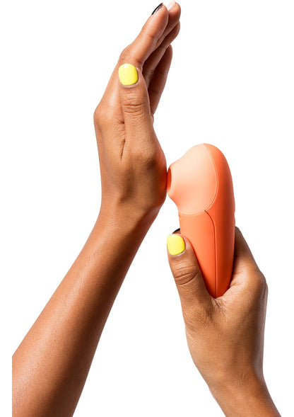 Oranje handheld massager met ronde kop, vastgehouden in twee handen