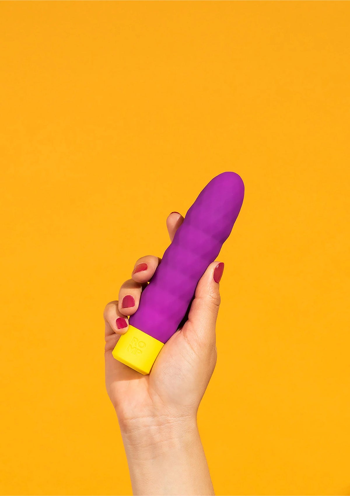 Paarse vibratiestaaf vastgehouden in hand met gele basis.