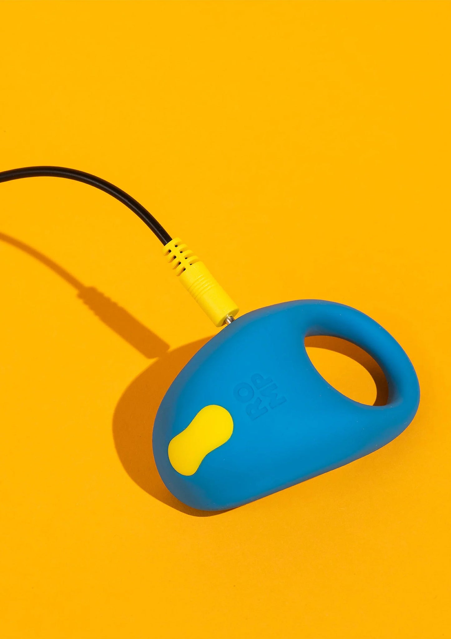 Vibrerende cockring blauw met geel uiteinde en zwart snoer, zijaanzicht