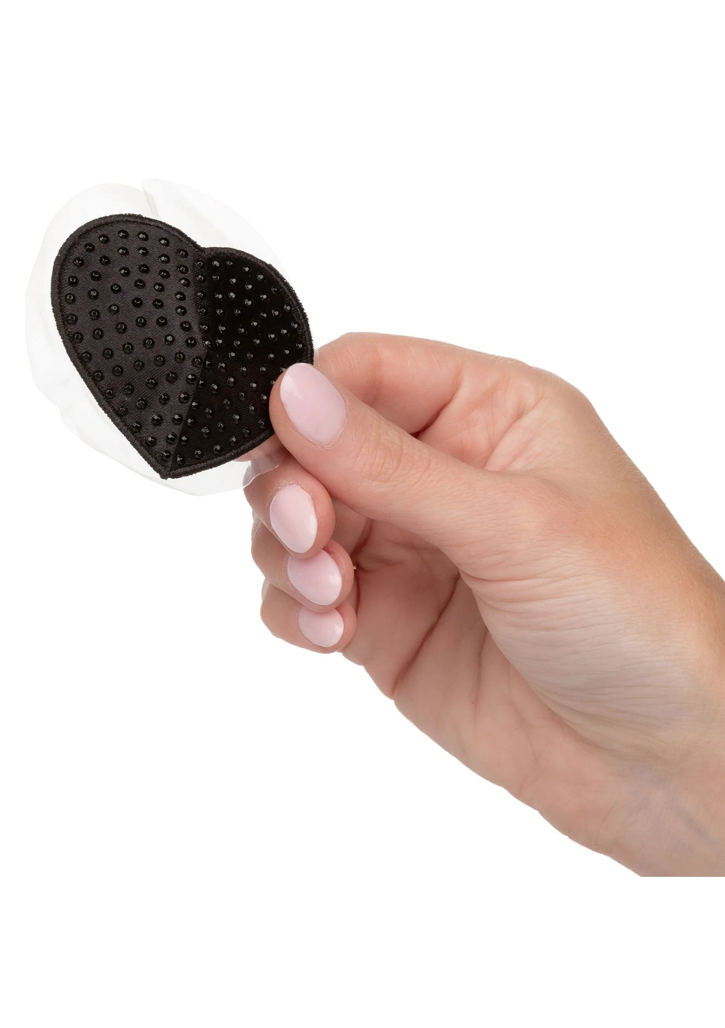 Hartvormige zwarte pasty met nopjes; hand pelt de plaklaag eraf