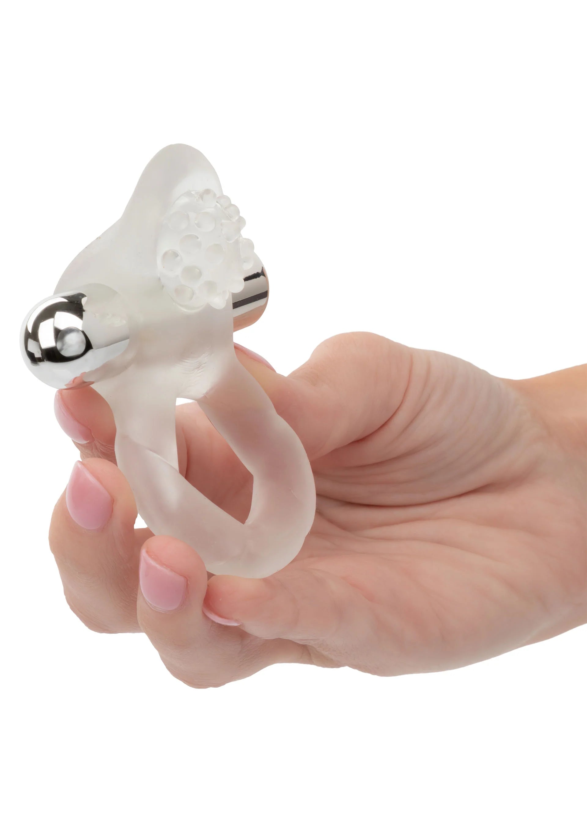 Cockring vastgehouden in hand: doorzichtige ring met nubbige vibratorkop en metalen uiteinde.