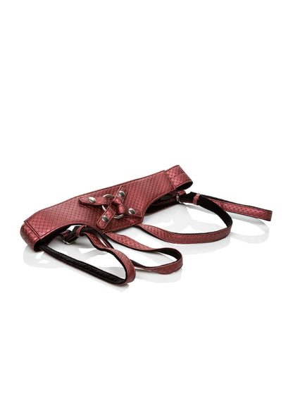 Rood harnas met open kruis, riemen en metalen ringen, plat op witte ondergrond