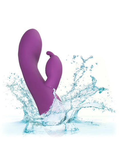 Paarse rabbit-vibrator met waternevel en spetters rond het apparaat