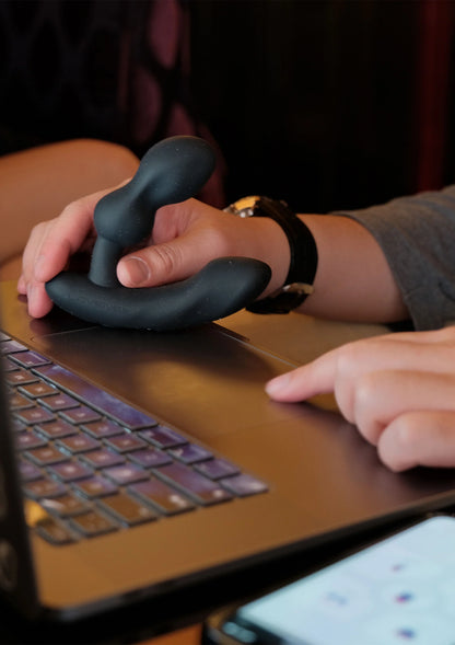 Anale massager donkergrijs/zwart wordt gebruikt, hand en vingergreep zichtbaar