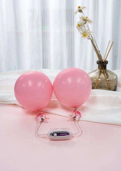 Roze nippelklemmen op twee roze ballonnen met bedienunit op voet