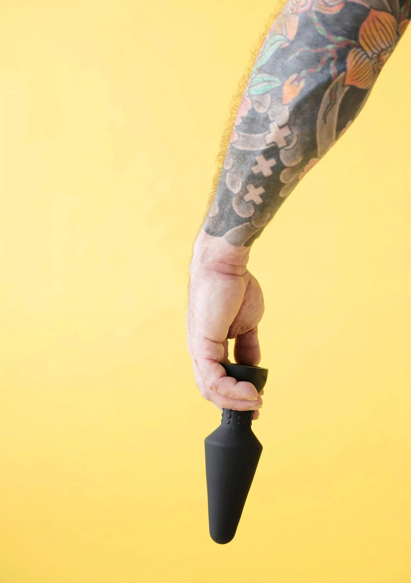 Zwarte rimming plug in gebruik, hand houdt de plug vast.