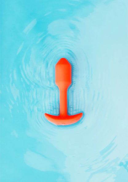 Trillende snug plug van B-Vibe, oranje plug in water met bubbels
