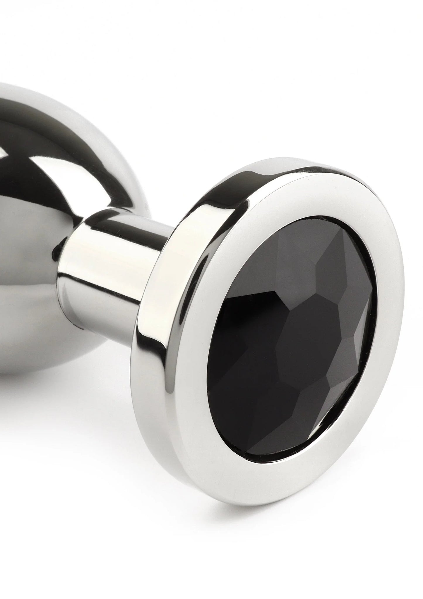 Anale plug close-up: zwarte ovale steen in metalen rand, gepolijste zilverkleur