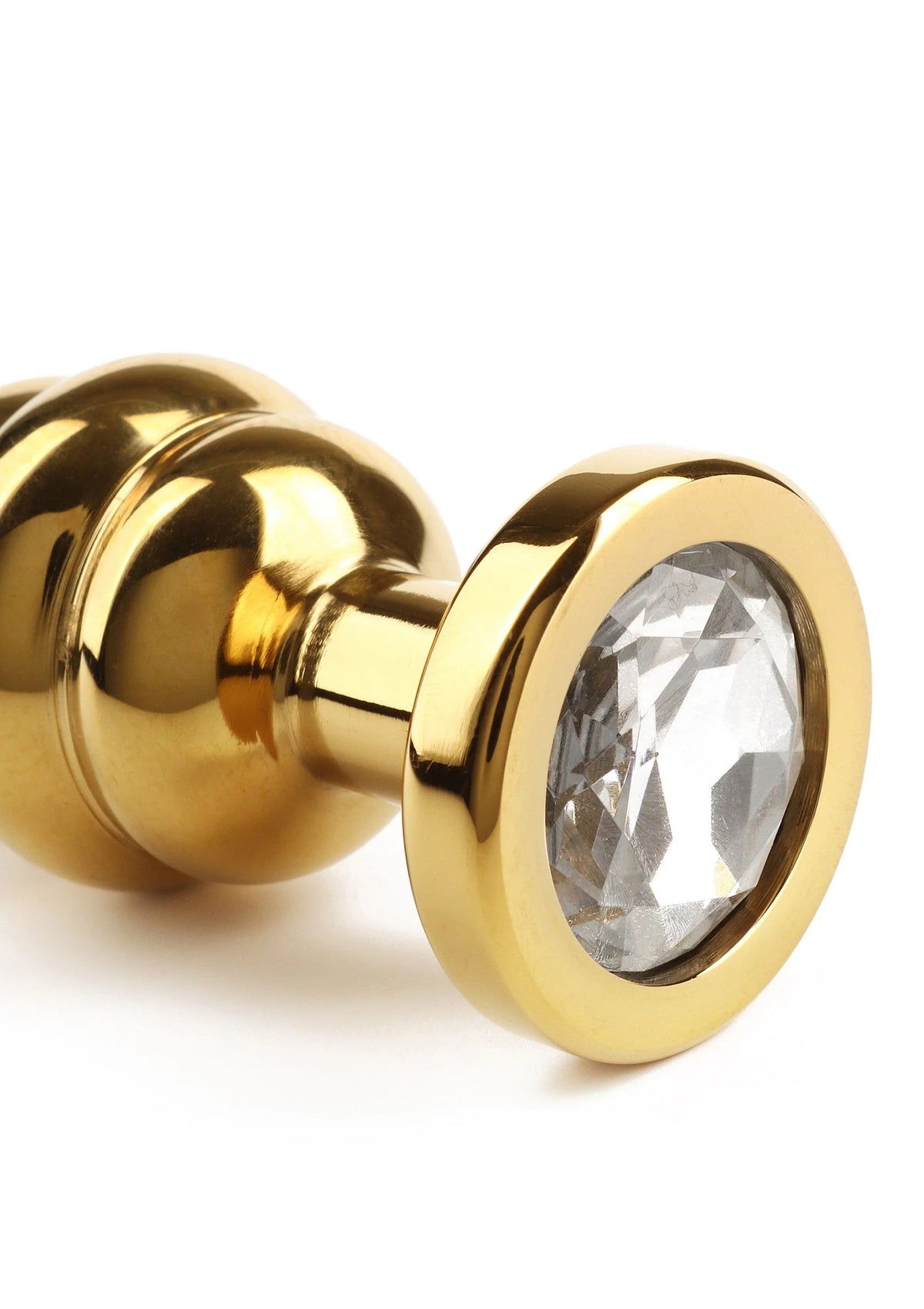 Gouden buttplug met gedraaide schacht en ronde kristalinzet aan de voorkant
