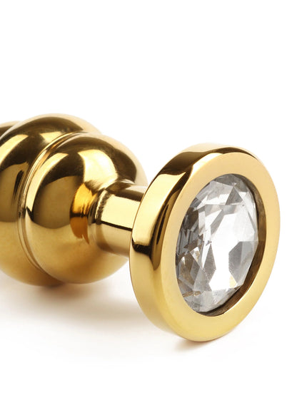 Gouden buttplug met gedraaide schacht en ronde kristalinzet aan de voorkant
