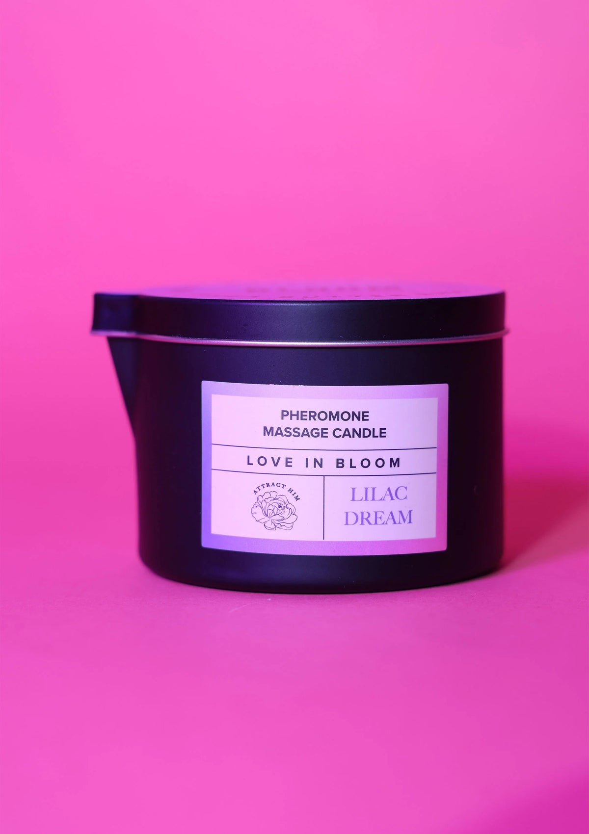 Zwarte massagekaars met etiket Love in Bloom en Lilac Dream, brandende pit zichtbaar.