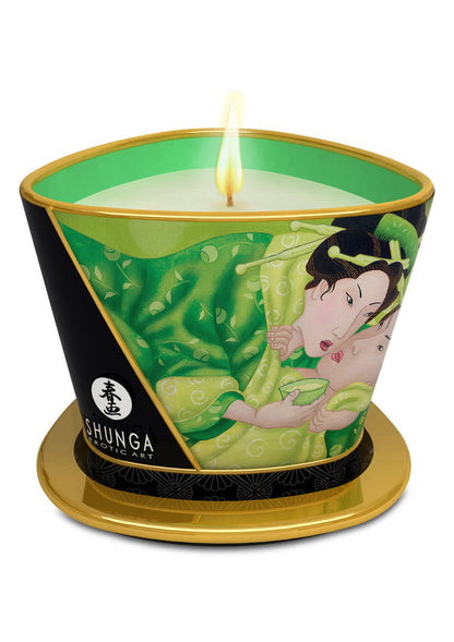 Massagekaars Shunga met groene illustratie en brandende kaars op gouden voet.