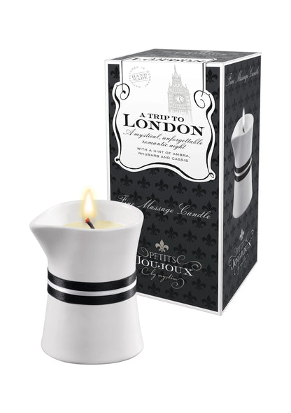 Massagekaars met vlam in witte houder naast zwarte London-cadeaudoos