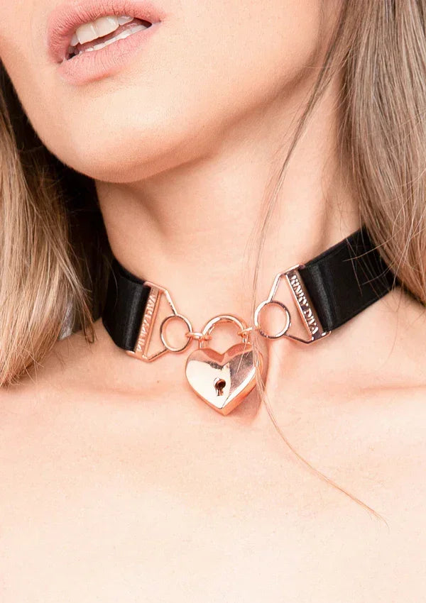 Zwarte choker met rosegoud hart en metalen ringen, met dun kettinkje